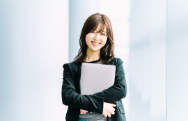 ノートパソコンを抱える女性のイメージ画像