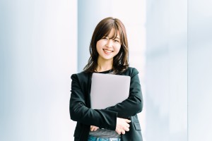 ノートパソコンを抱える女性のイメージ画像